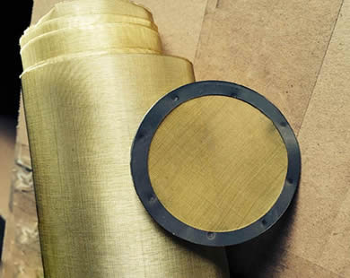 真鍮の金網のロールおよびゴム製包む端が付いている円形の真鍮フィルター ディスクは一緒に置かれる。